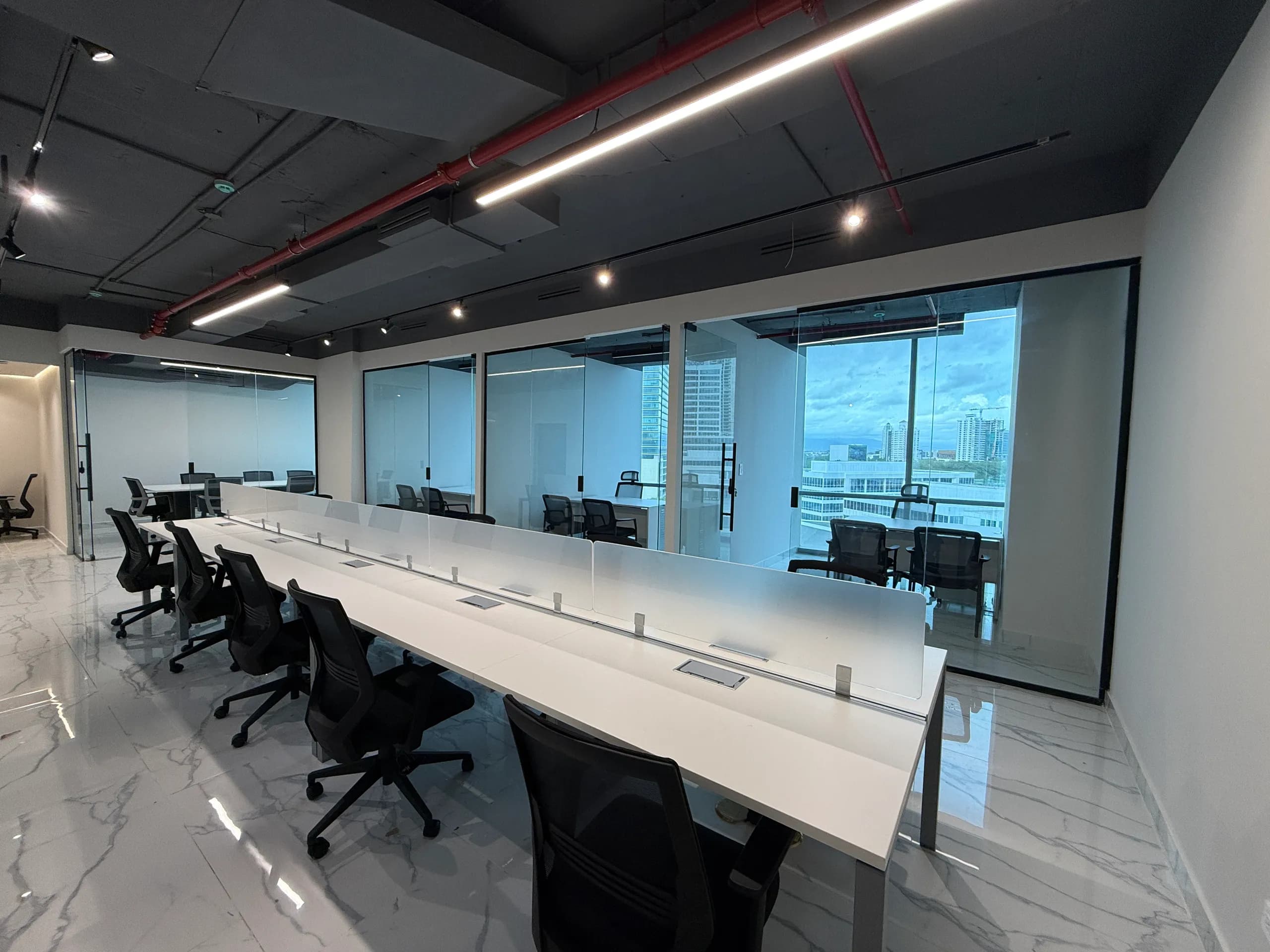 Áreas de trabajo abiertas con puestos y oficinas de cristal